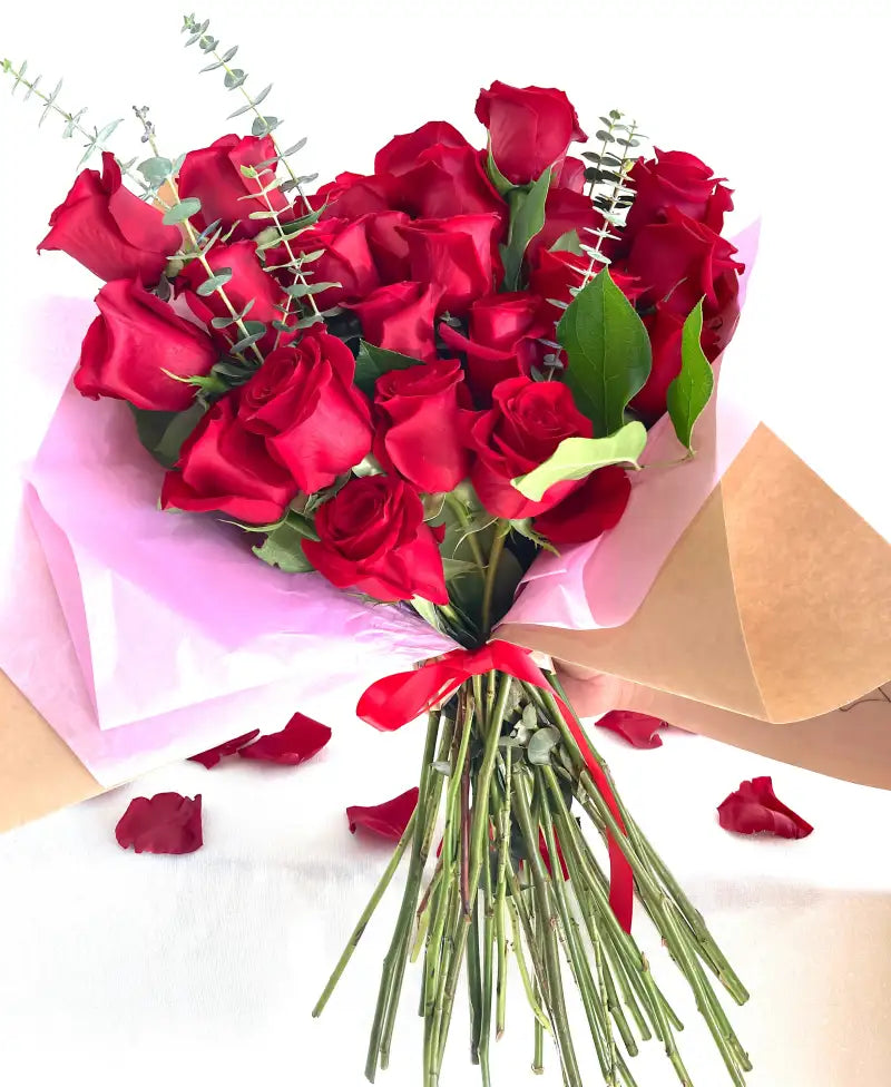 Two Dozen Bouquet of red roses with green leaves on a white background
