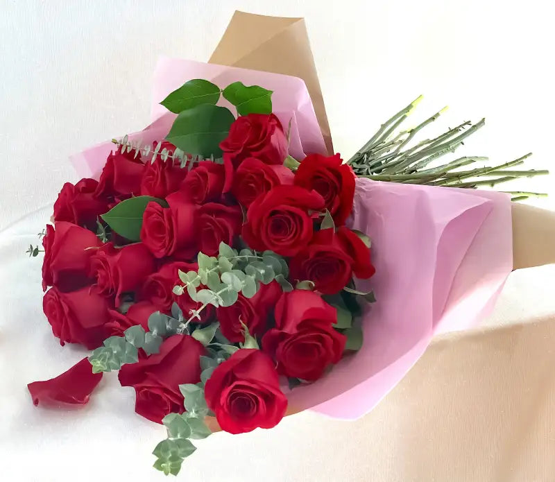 Two Dozen Bouquet of red roses with green leaves on a white background