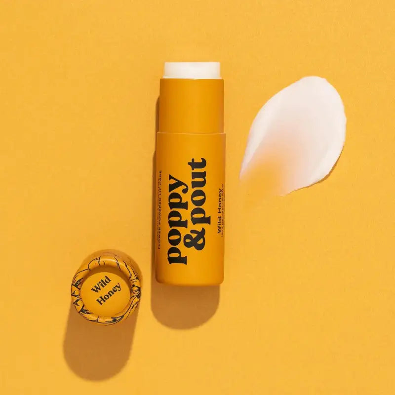 Yellow lip balm stick with 'Poppy & Pout' branding on a yellow background