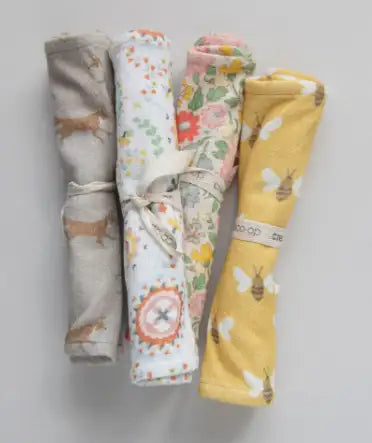 Four folded fabric swatches with floral patterns on a gray background