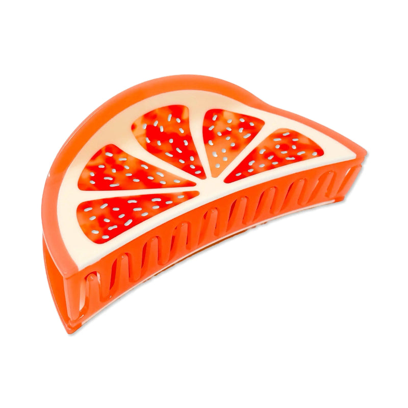 An orange and white hair claw clip designed in the shape of a sliced citrus fruit, shown on a plain white background.